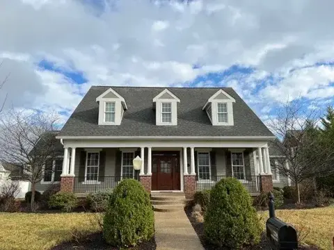 Shingle roof with three front dormers above a two-story home