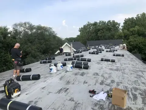 Roofing materials staged across a low-slope roof