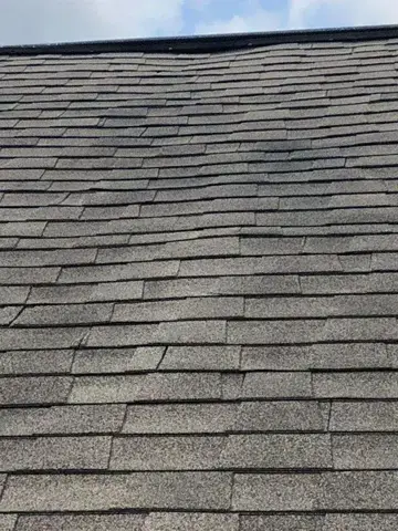 Weathered residential roof shingles before repair