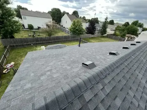 Completed roof slope beside a shingle ridge