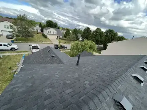 Completed shingle roof ridge and plumbing vent