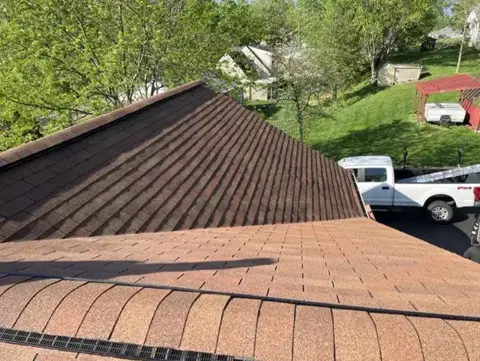 Completed brown shingle roof ridge and adjoining slopes