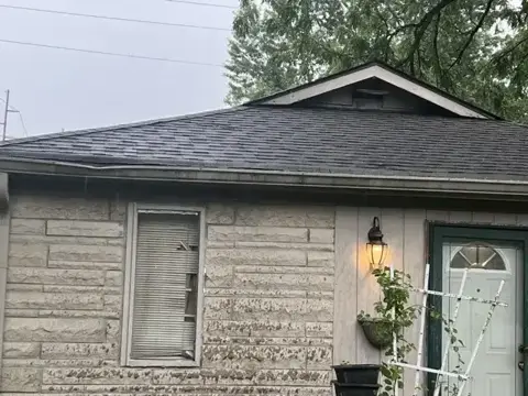 Completed residential shingle roof above a front entry
